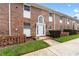 Charming brick townhome featuring a white front door with an arched window and manicured lawn at 4312 Lake Underhill Rd # 19-B, Orlando, FL 32803