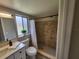 Modern bathroom featuring a walk-in shower with tiled walls, a vanity, and a decorative plant by the window at 4883 Cherokee Rose Dr, Orlando, FL 32808