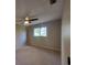 Comfortable bedroom with a ceiling fan, plush carpeting, and a window offering outdoor views at 4883 Cherokee Rose Dr, Orlando, FL 32808