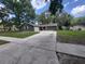 Charming single-story home with a well-manicured lawn and long driveway leading to an attached garage at 4883 Cherokee Rose Dr, Orlando, FL 32808