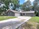 Charming single-story home with a gray exterior, attached garage, and a long driveway at 4883 Cherokee Rose Dr, Orlando, FL 32808