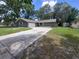 Charming single-story home with a well-manicured lawn and long driveway leading to an attached garage at 4883 Cherokee Rose Dr, Orlando, FL 32808