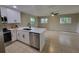 Bright kitchen with stainless steel appliances, white cabinets, and an open layout to the living area at 4883 Cherokee Rose Dr, Orlando, FL 32808