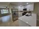 Modern kitchen featuring stainless steel appliances, white cabinets, and a sleek breakfast bar at 4883 Cherokee Rose Dr, Orlando, FL 32808
