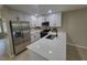 Modern kitchen featuring stainless steel appliances, white cabinets, and a sleek breakfast bar at 4883 Cherokee Rose Dr, Orlando, FL 32808