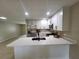 Modern kitchen featuring stainless steel appliances, white cabinets, and a sleek breakfast bar at 4883 Cherokee Rose Dr, Orlando, FL 32808
