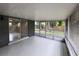 Spacious screened porch with grey painted walls and access to backyard and kitchen at 4883 Cherokee Rose Dr, Orlando, FL 32808