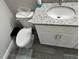 Bathroom showcasing vanity with granite countertops, white cabinets, fixtures, toilet, and modern flooring at 51 Fir Dr, Ocala, FL 34472