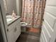 Bathroom featuring a white single sink vanity, granite countertop, and tub with patterned shower curtain at 51 Fir Dr, Ocala, FL 34472