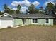 Lovely single-story home featuring a two-car garage, a welcoming front door, and a well-maintained lawn at 51 Fir Dr, Ocala, FL 34472