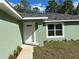Welcoming entryway featuring a white front door with glass accents and manicured landscaping at 51 Fir Dr, Ocala, FL 34472