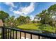 Scenic backyard view with lush greenery, pond, and blue sky from a balcony with black metal railings at 5287 Cypress Ct # 724, Orlando, FL 32811