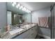 Bathroom featuring double sink vanity, granite countertops, a large mirror, and a glass shower at 5287 Cypress Ct # 724, Orlando, FL 32811