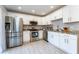 Bright kitchen boasts stainless steel appliances, white cabinets, granite countertops, and tile flooring at 5287 Cypress Ct # 724, Orlando, FL 32811