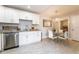 Well lit kitchen with stainless steel appliances, white cabinets, granite countertops, and a dining table under a chandelier at 5287 Cypress Ct # 724, Orlando, FL 32811
