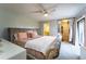 Main bedroom featuring a decorative headboard, ceiling fan, slider door to a balcony, and ensuite bath at 5287 Cypress Ct # 724, Orlando, FL 32811