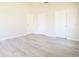 Bedroom featuring neutral walls, gray wood floors and three doors at 6569 Long Breeze N Rd, Orlando, FL 32810