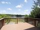 Relaxing view from a wooden deck overlooking a serene lake surrounded by lush greenery on a sunny day at 6569 Long Breeze N Rd, Orlando, FL 32810