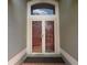 Front door with decorative glass panels and transom window at 6569 Long Breeze N Rd, Orlando, FL 32810