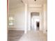 Bright hallway leading to a kitchen area, showcasing open layout and tile flooring at 6569 Long Breeze N Rd, Orlando, FL 32810