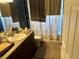 Bathroom featuring vanity sink with granite counter top and a shower tub with curtain at 7047 Sw 131St Loop, Ocala, FL 34473