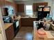 Functional kitchen with dark wood cabinets, black appliances, and laminate countertops at 7047 Sw 131St Loop, Ocala, FL 34473