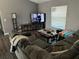 Cozy living room with gray walls, large sectional sofa, and entertainment center with a TV at 7047 Sw 131St Loop, Ocala, FL 34473