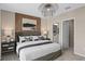 A cozy bedroom with a plush bed, decorative lighting, and a view into the bathroom at 7125 Rosy Sky Ave, Orlando, FL 32829