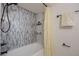Bright bathroom featuring a tub with stylish tiling and a sleek black shower head at 7852 Broken Arrow Trl, Winter Park, FL 32792
