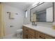 Bathroom featuring a vanity, a large mirror, and stylish fixtures with a shower visible in the mirror at 7852 Broken Arrow Trl, Winter Park, FL 32792