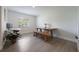 Dining area with natural wood table, bench, and desk workspace, illuminated by a window at 7852 Broken Arrow Trl, Winter Park, FL 32792