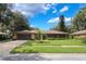 Well-manicured home featuring a spacious front yard, long driveway, and attached two car garage at 7852 Broken Arrow Trl, Winter Park, FL 32792