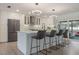Kitchen with white cabinets, subway tile backsplash, black accents and island with seating at 7852 Broken Arrow Trl, Winter Park, FL 32792