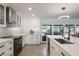 Bright kitchen with stainless steel appliances, island seating, and access to an outdoor seating area at 7852 Broken Arrow Trl, Winter Park, FL 32792