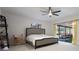 Large bedroom with ceiling fan, slider doors to porch, shelving, and neutral colored carpet at 7852 Broken Arrow Trl, Winter Park, FL 32792