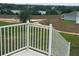 Expansive backyard view with white railings, green space, and distant lake at 798 Kapi Dr, Groveland, FL 34736