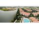 Scenic aerial view featuring a community pool, buildings with orange roofs, and a picturesque lake at 8024 Cool Breeze Dr # 132, Orlando, FL 32819