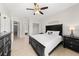 This well-lit bedroom features neutral walls, tiled floor, ceiling fan, and a modern black bed and dresser set at 8024 Cool Breeze Dr # 132, Orlando, FL 32819