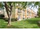 Townhome exterior with manicured lawn, mature tree, and private balconies at 8024 Cool Breeze Dr # 132, Orlando, FL 32819