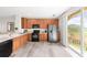 Modern kitchen with stainless steel appliances, wood cabinetry, and access to a patio at 8024 Cool Breeze Dr # 132, Orlando, FL 32819