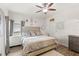Serene bedroom with a decorative headboard, ceiling fan, wood-look floors, and ample natural light at 8495 Lake Amhurst Trl, Orlando, FL 32829