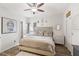 Inviting bedroom features a comfortable bed, ceiling fan, decorative art, and wood-look flooring at 8495 Lake Amhurst Trl, Orlando, FL 32829