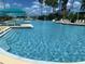 Beautiful community pool with lounge chairs, umbrellas, and water slide feature at 8495 Lake Amhurst Trl, Orlando, FL 32829