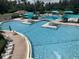 Large community swimming pool surrounded by lounge chairs and umbrellas at 8495 Lake Amhurst Trl, Orlando, FL 32829