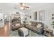Bright living room with ceiling fan, gray sofa, laminate floors, and decorative art at 8495 Lake Amhurst Trl, Orlando, FL 32829