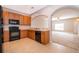 Kitchen with black appliances, wooden cabinets, and a view into the cozy living room, great for entertaining at 9140 Grey Moss Dr, Orlando, FL 32832