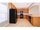 Functional kitchen showcasing wooden cabinets, black appliances, tile flooring, and ample countertop space at 9140 Grey Moss Dr, Orlando, FL 32832