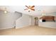 Cozy living room with carpet, ceiling fan, and an archway leading to the kitchen and other rooms at 9140 Grey Moss Dr, Orlando, FL 32832