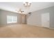 Bright living room featuring neutral walls, carpet, a ceiling fan, and a staircase to the upper level at 9140 Grey Moss Dr, Orlando, FL 32832