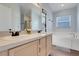 Bathroom featuring double sinks, garden tub, and large window providing natural light at 915 Lockbreeze Dr, Davenport, FL 33897